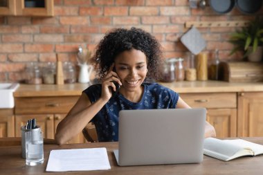 Gülümseyen Afrikalı Amerikalı kadın telefonda konuşuyor.