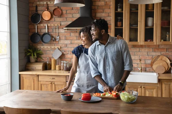 Feliz pareja afroamericana soñadora cocinando juntos en la cocina —  Fotos de Stock