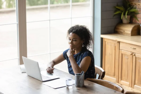 Top view satisfied thoughtful African American woman using laptop — Stock Photo, Image