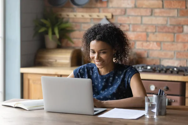 Close up smiling African American woman using laptop in kitchen — Stock Photo, Image