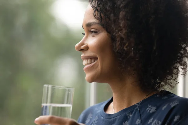 Gros plan femme afro-américaine souriante tenant un verre d'eau — Photo