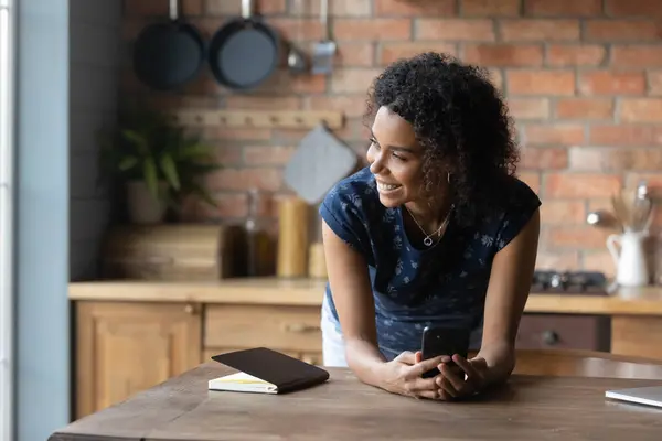 Gros plan souriant femme afro-américaine rêveuse distraite du téléphone — Photo