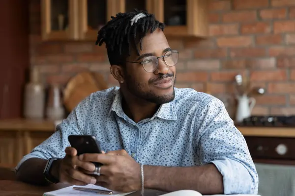 Närbild drömmande afroamerikansk man distraherad från telefonen — Stockfoto