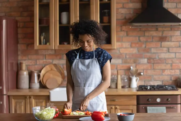 Sonriente mujer afroamericana cortando verduras frescas, cocinando ensalada —  Fotos de Stock