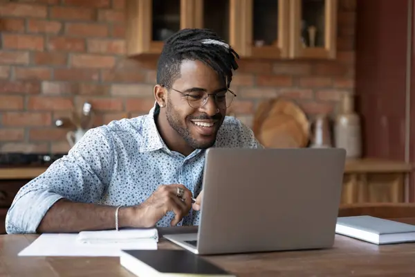 Close up smiling African American man wearing glasses using laptop — Stock Photo, Image