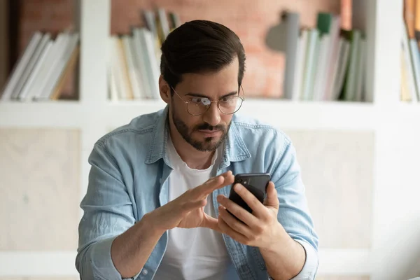 L'uomo concentrato usa il cellulare per leggere le notizie online — Foto Stock