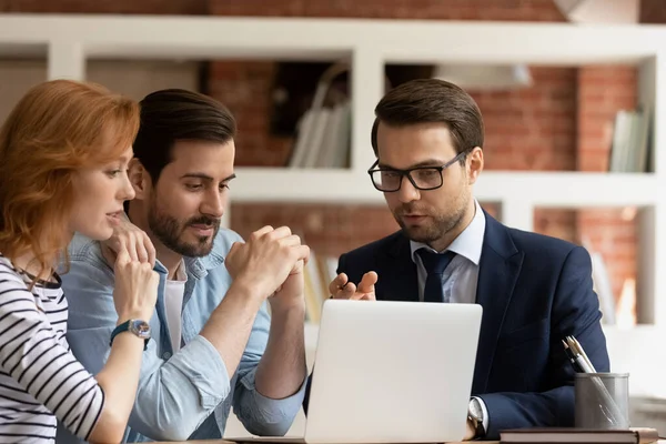 Hombre agente inmobiliario consultar pareja caucásica en la reunión — Foto de Stock