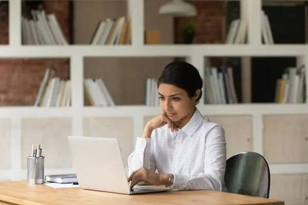 Zamyślony Indian kobieta praca na laptop myślenia — Zdjęcie stockowe