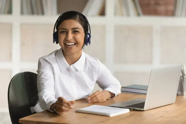 Portret van lachende Indiase vrouw in hoofdtelefoon studie op laptop — Stockfoto