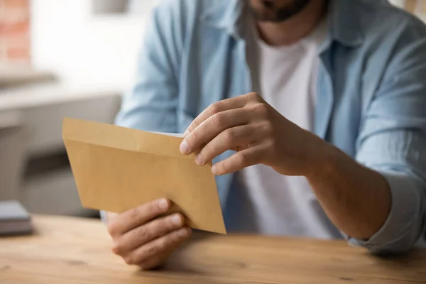 Close up af mandlige medarbejder åben konvolut med brev - Stock-foto