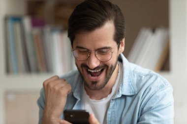 Neşeli adam bak cep telefonu ekranında zafer kazanan piyangoya