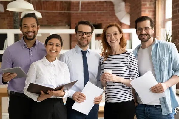 Retrato de colegas multiétnicos sonrientes posando en el cargo — Foto de Stock