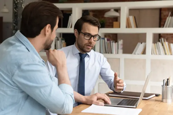 Colegas do sexo masculino brainstorm trabalhando no computador no escritório — Fotografia de Stock