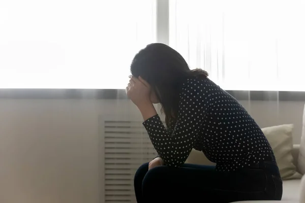 Desesperado jovem mulher sentar na cama sofrendo de problemas psicológicos — Fotografia de Stock