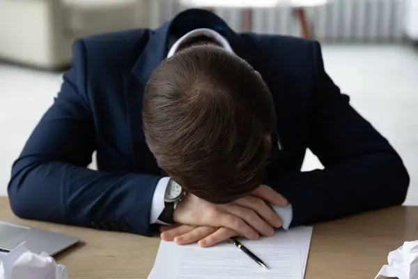 Uitgeputte mannelijke werknemer in slaap vallen op het werk — Stockfoto