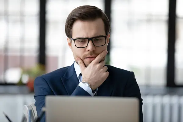 Pensive businessman look at laptop making decision — Stock fotografie