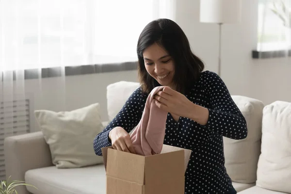 Happy asijské žena zákazník vybalit balíček objednaný v módní butik — Stock fotografie