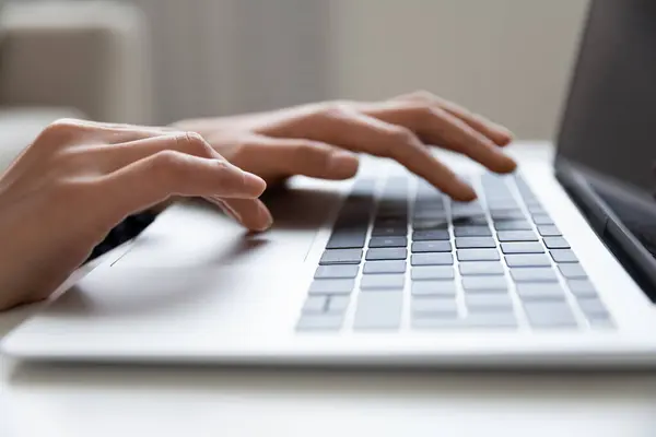 Modern dizüstü bilgisayarın klavyesinde yazan genç kadın elleri. — Stok fotoğraf