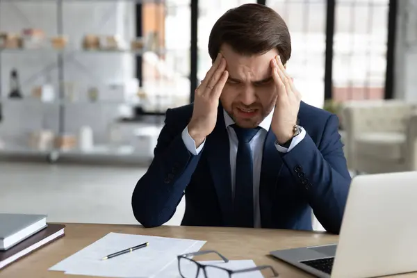 Empresario enfermo sufre de dolor de cabeza trabajando en la computadora —  Fotos de Stock