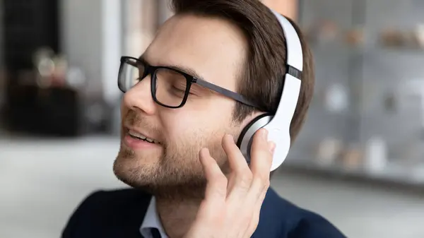 Rustig gelukkige zakenman in koptelefoon luisteren naar muziek — Stockfoto