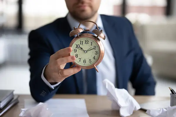 Close up of businessman hold clock worried about deadline