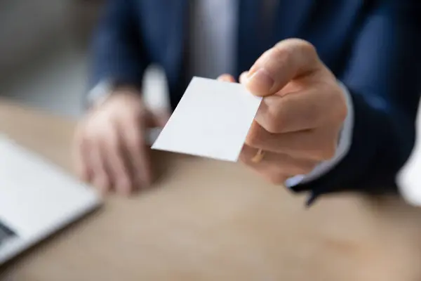 Primer plano de hombre de negocios ofrecen tarjeta de visita al cliente —  Fotos de Stock