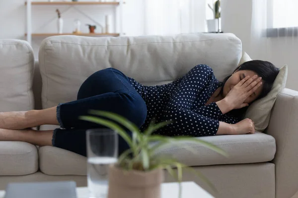 Депрессивная молодая азиатская женщина лежит на диване плакать плохо — стоковое фото