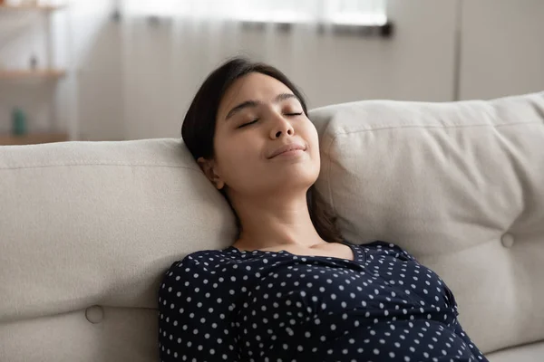 Felice donna asiatica rilassarsi dormire sul divano con gli occhi chiusi — Foto Stock
