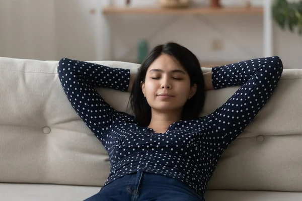 Jeune dame asiatique ayant du repos sur le canapé à l'heure du jour — Photo