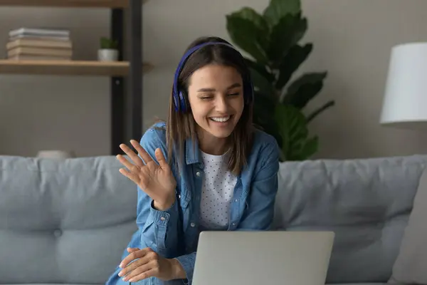 Happy young woman in headphones say hi making video call — Stock Photo, Image