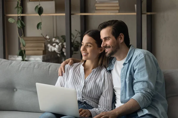 Millennial familia pareja soñando distraído de navegar por Internet en el ordenador portátil — Foto de Stock