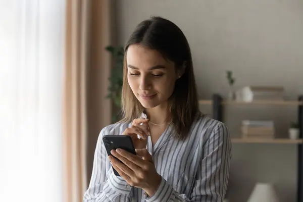 Teen female read pleasant message from beloved person on phone — Stock Photo, Image