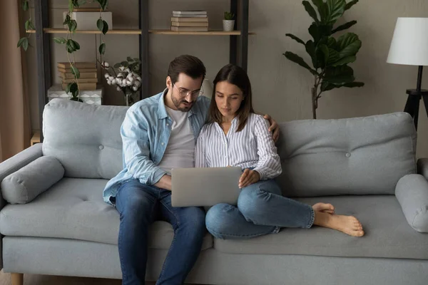 Ernstes junges Paar mit Laptop überlegt Hochzeitsplanung — Stockfoto