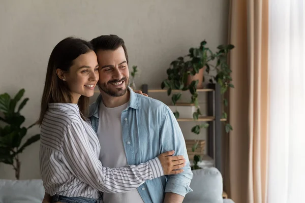 Coppia romantica innamorata che si abbraccia alla finestra sognando il matrimonio — Foto Stock