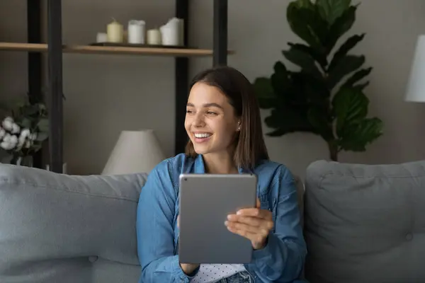 Laughing female teenager getting funny messages from friend on tablet — Stock Photo, Image