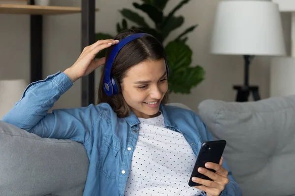 Female teenager in headset play mobile game satisfied with sound — Stock Photo, Image