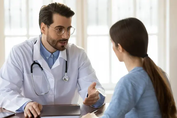 Příjemný mladý hezký mužský lékař mluví s pacientem. — Stock fotografie