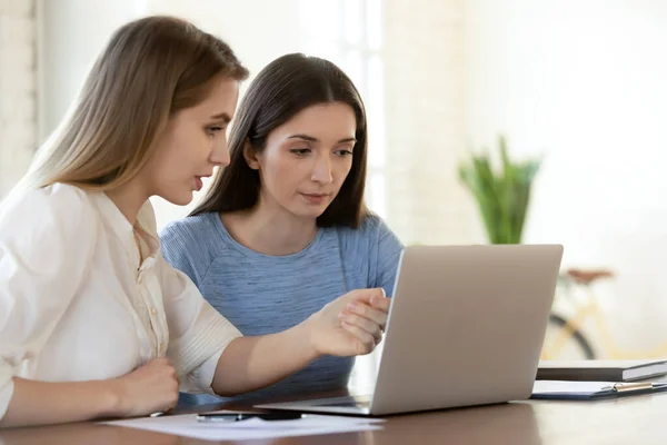 Focalizzato giovane leader femminile aiutare collega principiante. — Foto Stock