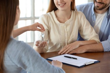 Emlakçıdan anahtar alan mutlu genç çift.