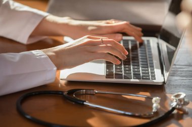 Laptop üzerinde çalışan genç kadın pratisyen hekimi kapatın..