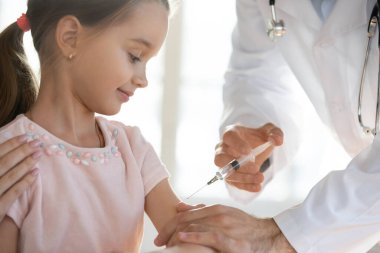 Doktor küçük kız hastaya iğne yaptı.