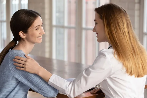 Smiling professional female general practitioner telling good news to patient. — Stock Photo, Image