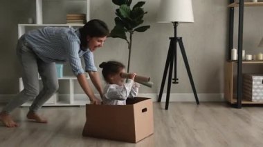 Küçük kızıyla karton kutu iten mutlu bir anne..