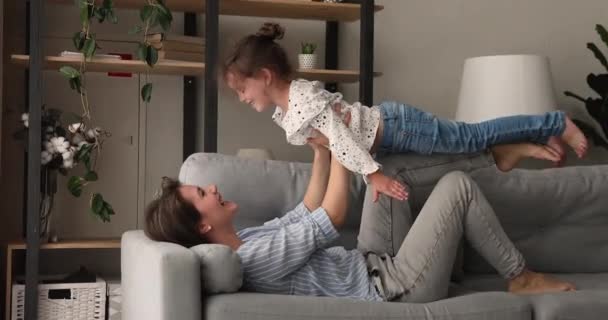 Sorrindo carinhoso jovem mãe jogando avião com a filha. — Vídeo de Stock