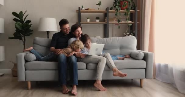 Familia feliz vinculación con niños pequeños usando la computadora en casa. — Vídeos de Stock