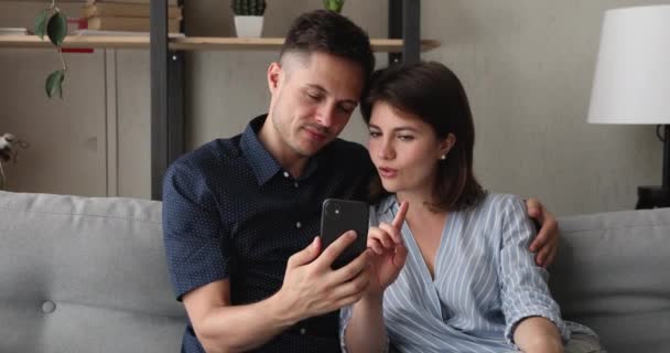 스마트폰을 사용하여 온라인 쇼핑을 하는 행복 한 젊은 가족 커플. — 비디오