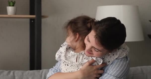 Любящая молодая мать обнимает маленькую дошкольницу дочь. — стоковое видео