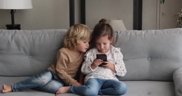 Gelukkig twee kleine kinderen met behulp van smartphone thuis. — Stockvideo