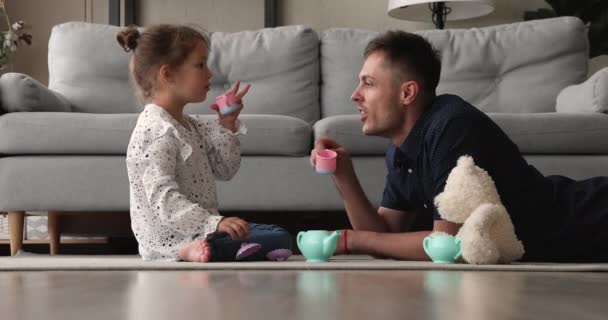 Feliz niña adorable pequeña jugando ceremonia del té con papá. — Vídeos de Stock