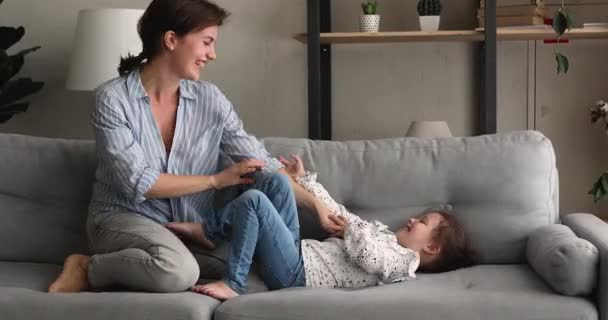 Energetische dolblij klein kind meisje spelen met mama of nanny. — Stockvideo